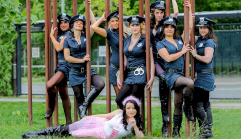 Junggesellinnen beim JGA Fotoshooting mit Sexy US Polizeiuniformen posen draußen an Stangen